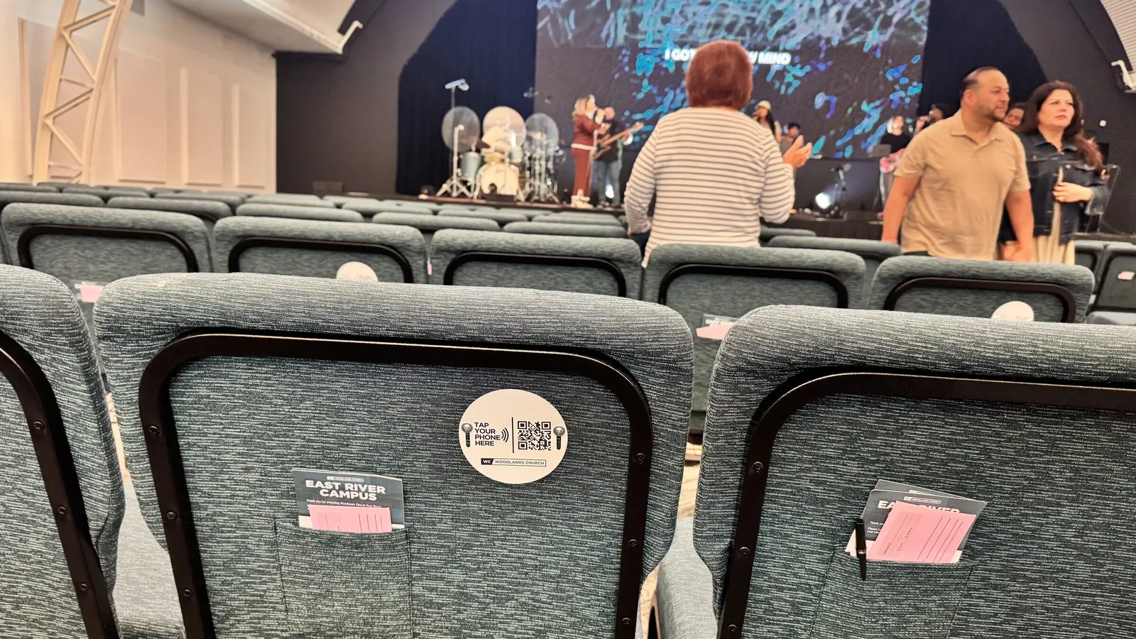 A multisite church auditorium with NFC tap plates on every seat for tap to give and tap to donate